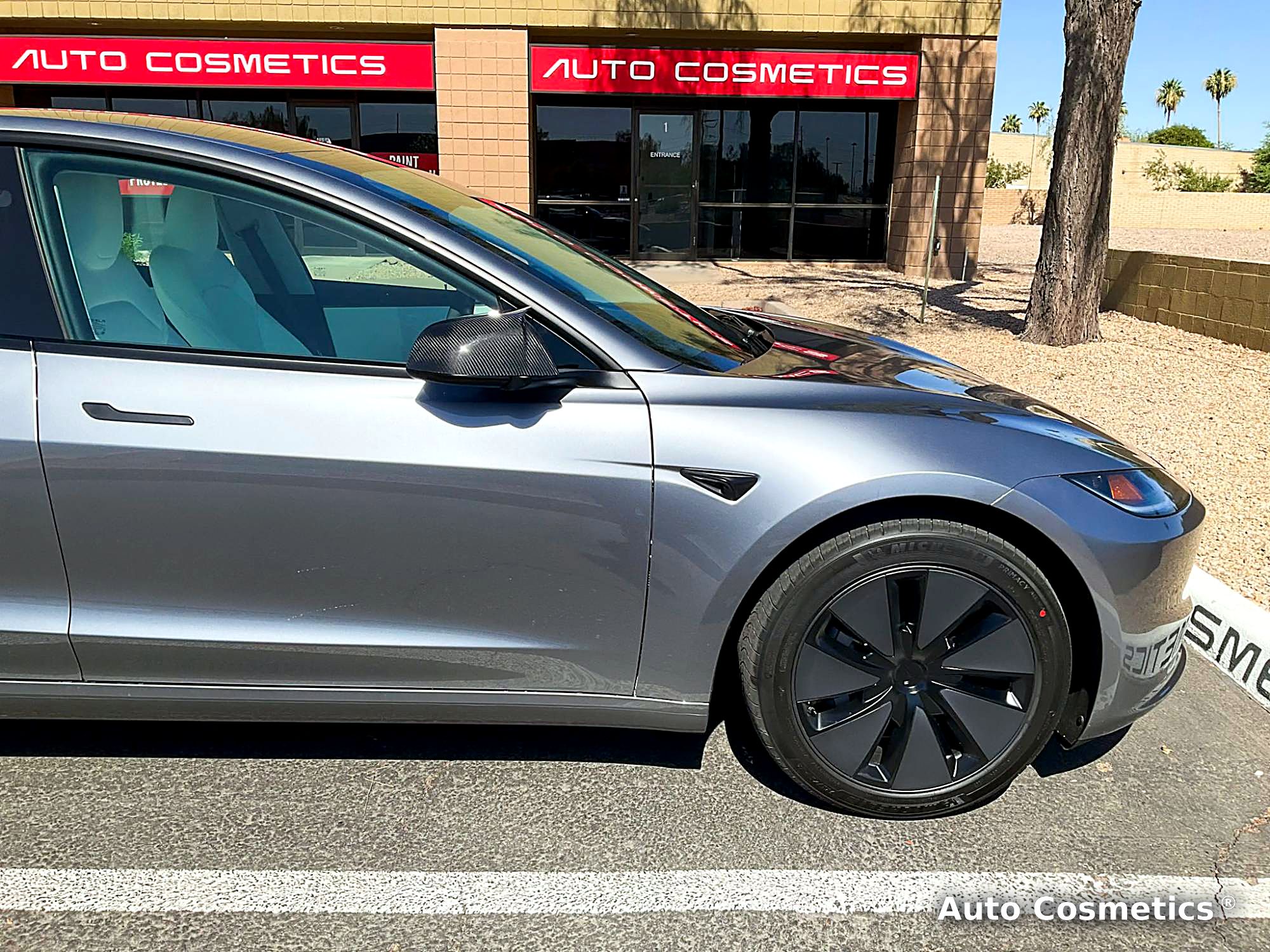 Tesla Model 3 with paint protection film in front of the Auto Cosmetics signs in Chandler, Arizona